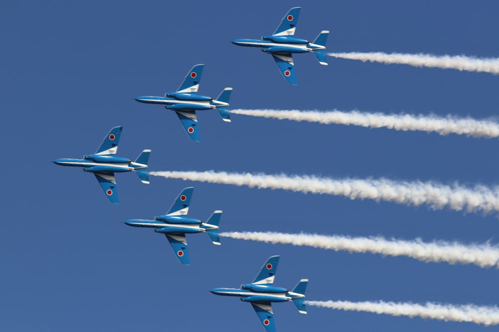 four blue and yellow jet planes