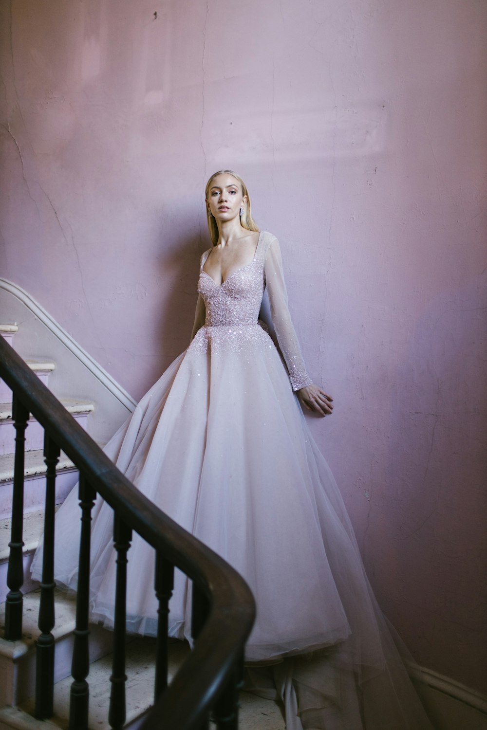 woman in white wedding dress standing on staircase