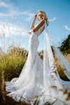 woman in white wedding dress standing on green grass field during daytime