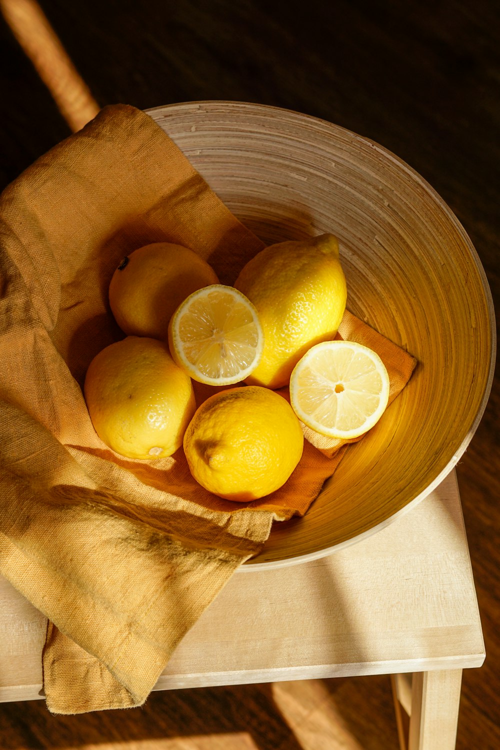 Fruta de limón amarillo en cubo de madera marrón