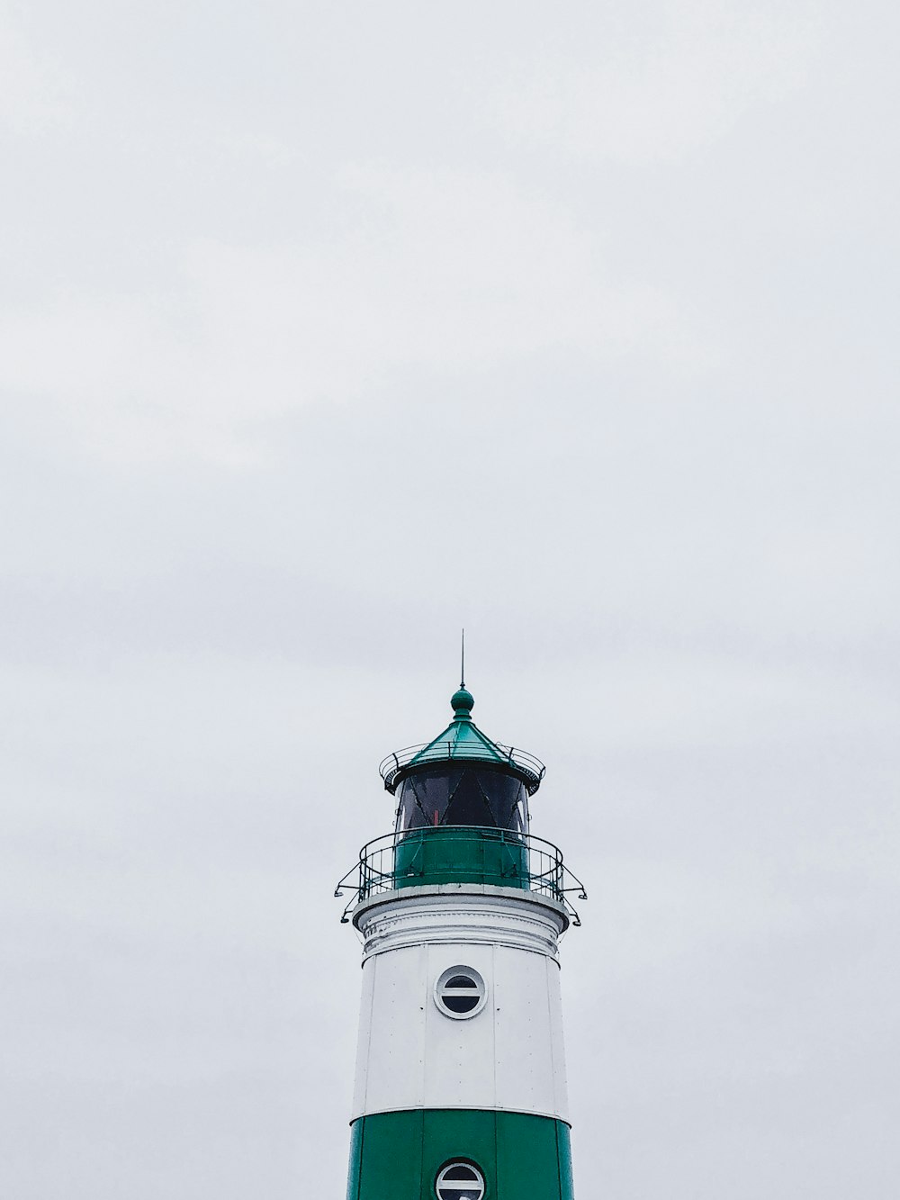 farol branco e verde sob o céu branco durante o dia