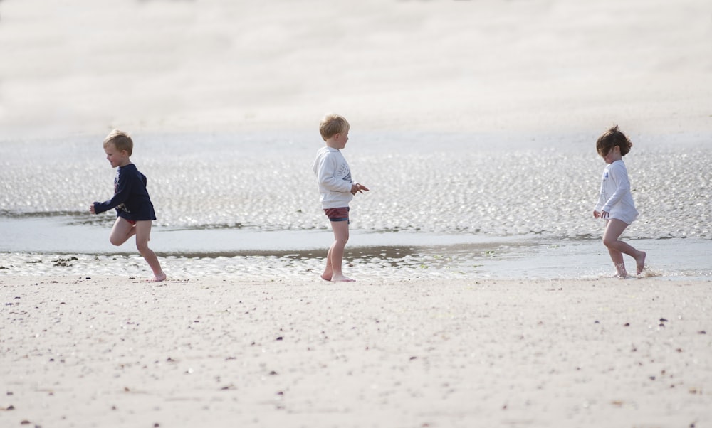 girl in white shirt walking on beach during daytime