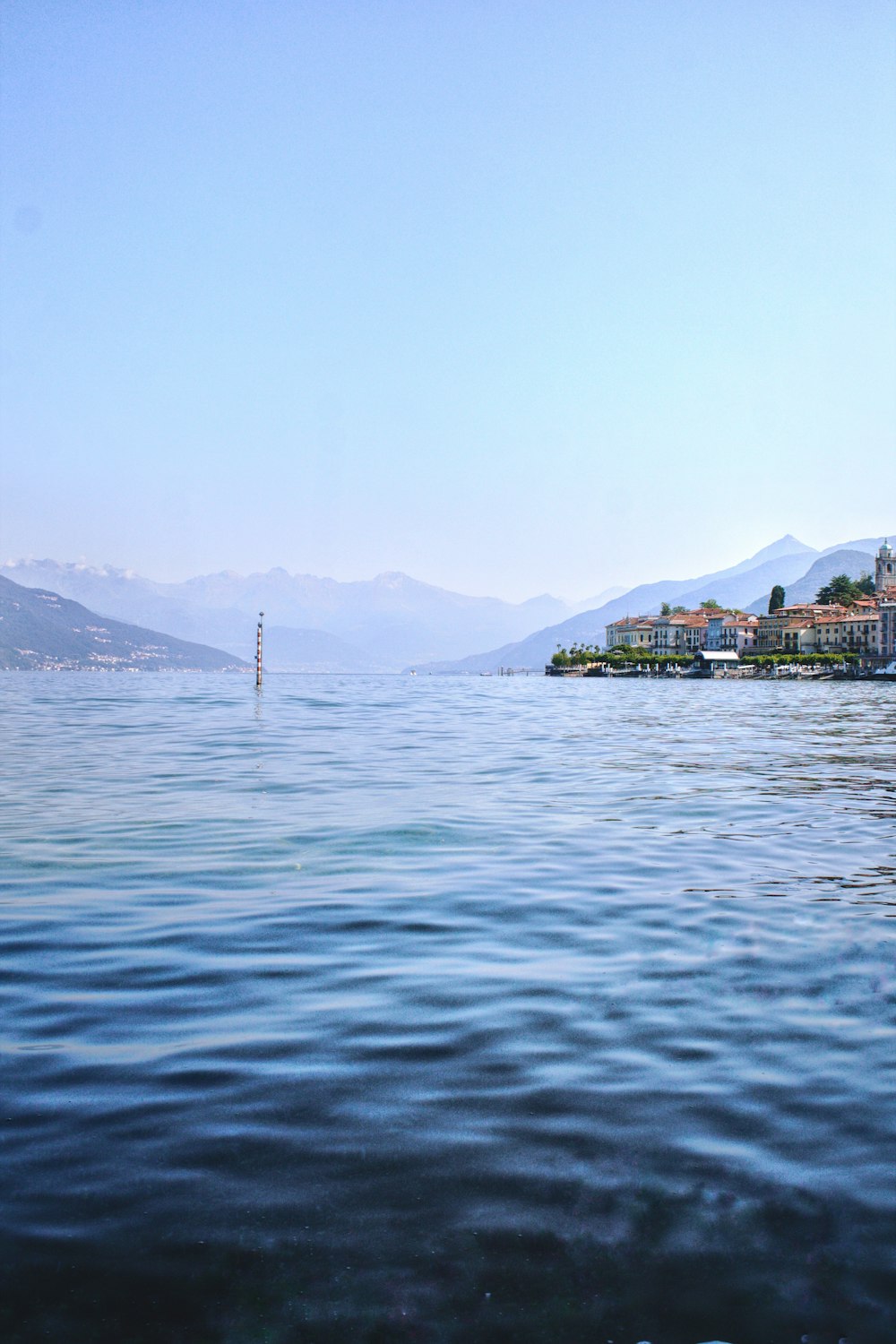 body of water near mountain during daytime