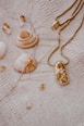 gold and white necklace on white textile