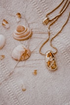 A collection of sea-inspired jewelry pieces artfully displayed on a sandy beach blanket.