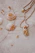 Close-up of a delicate seashell necklace resting on a soft knitted scarf in coastal colors.