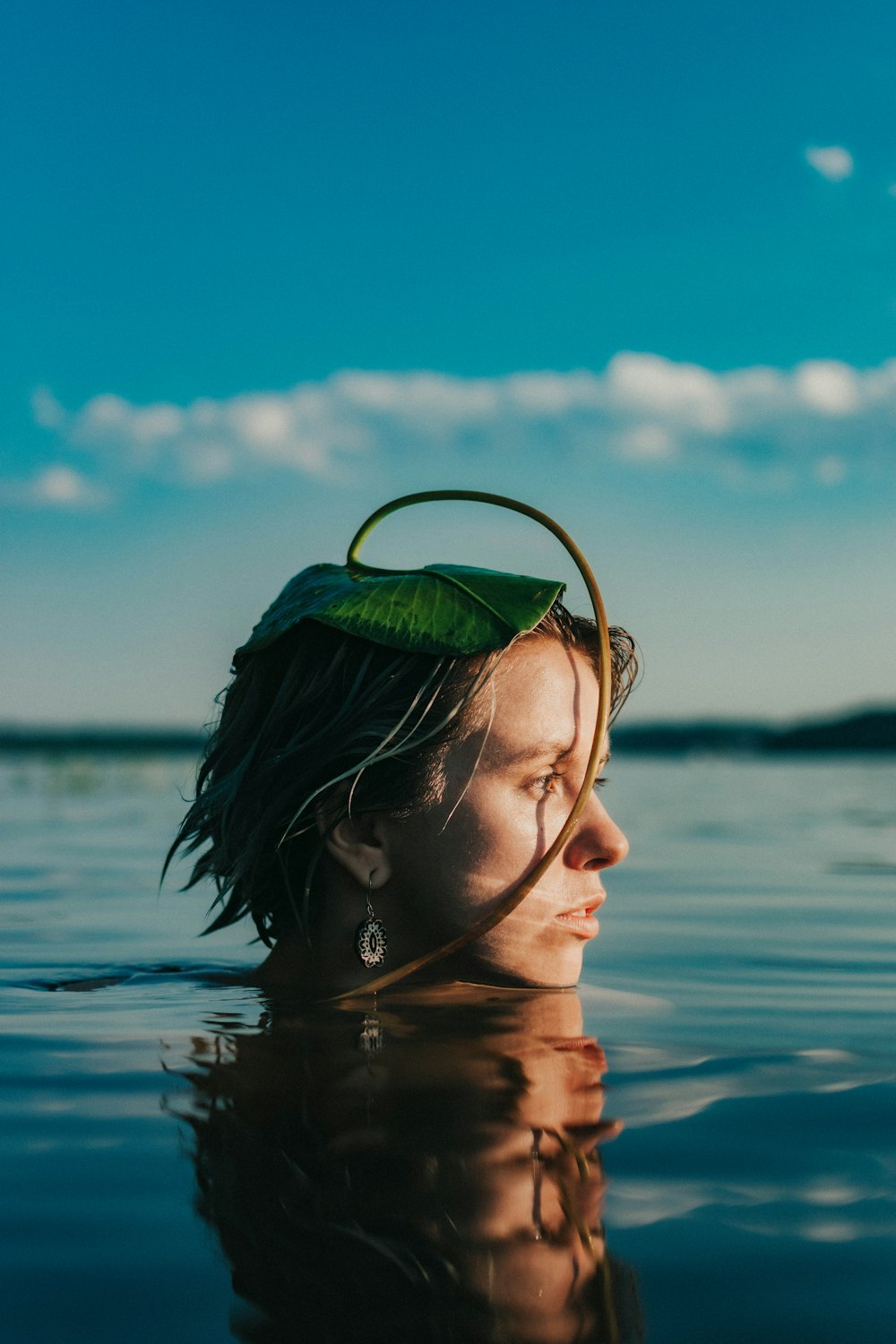woman in green and white floral headband on water during daytime