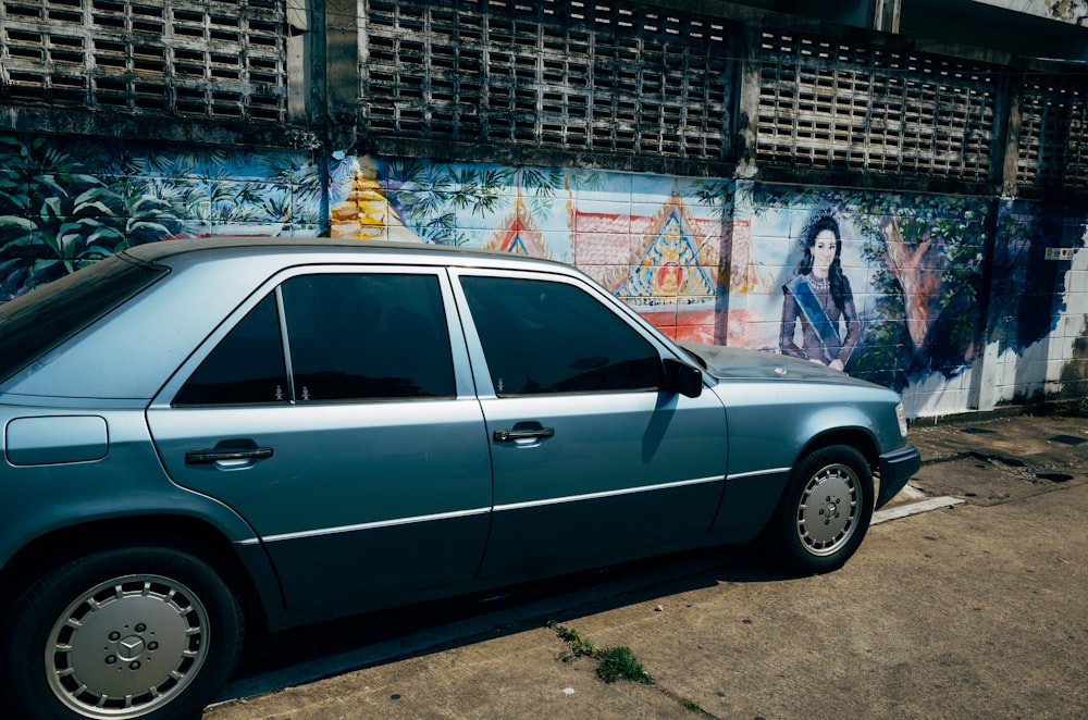 woman in blue denim jacket standing beside white sedan