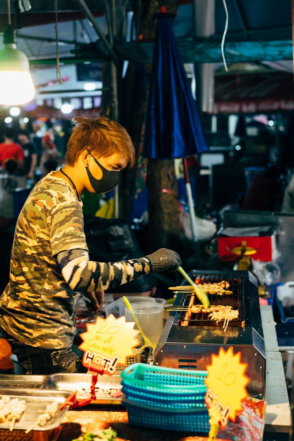 man in yellow and brown long sleeve shirt holding burning charcoal