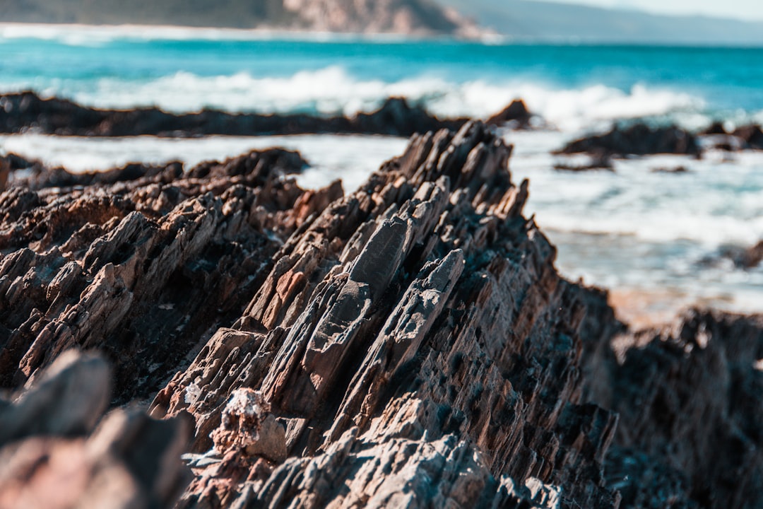 brown rock formation near body of water during daytime