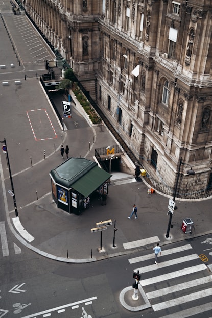 green stand on road near people walking on sidewalk during daytime