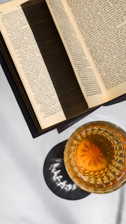 Warm sunlight casting shadows on a smooth wooden tray with a cup of tea and an open book