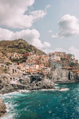 houses near body of water under cloudy sky during daytime