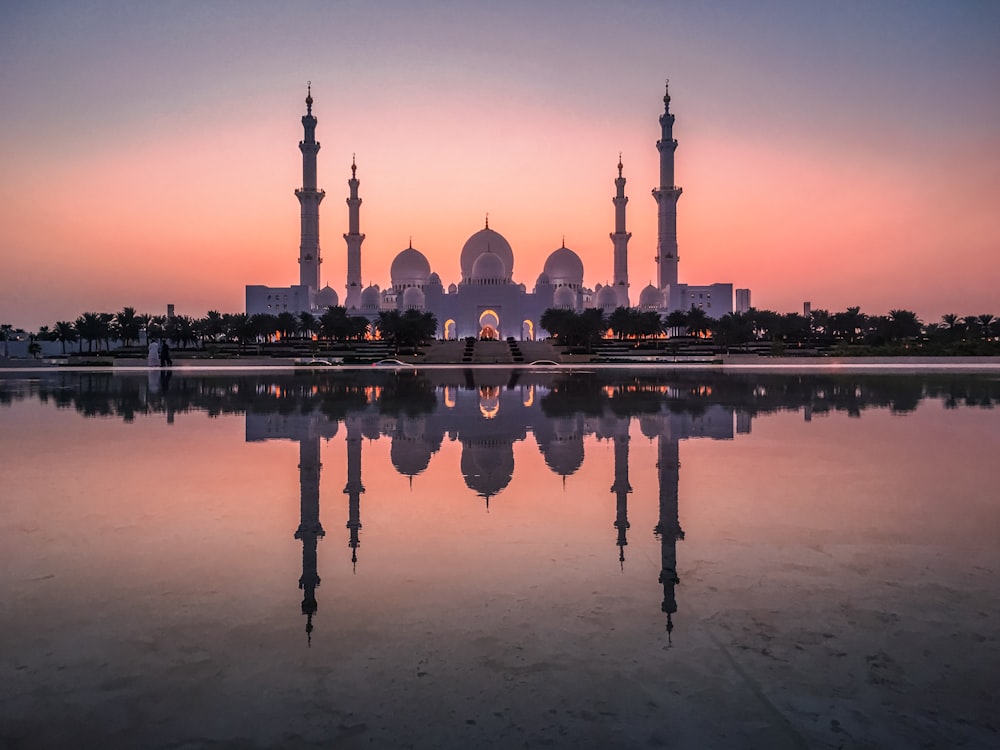white and gold mosque near body of water during daytime