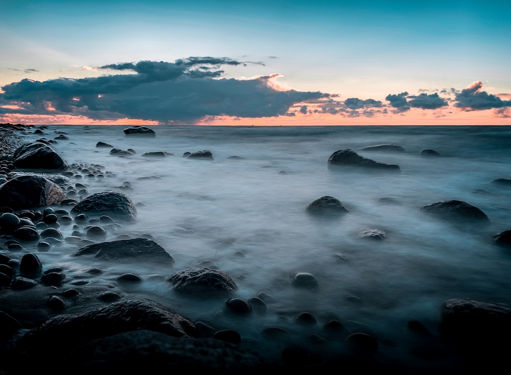 sea waves crashing on rocks during sunset