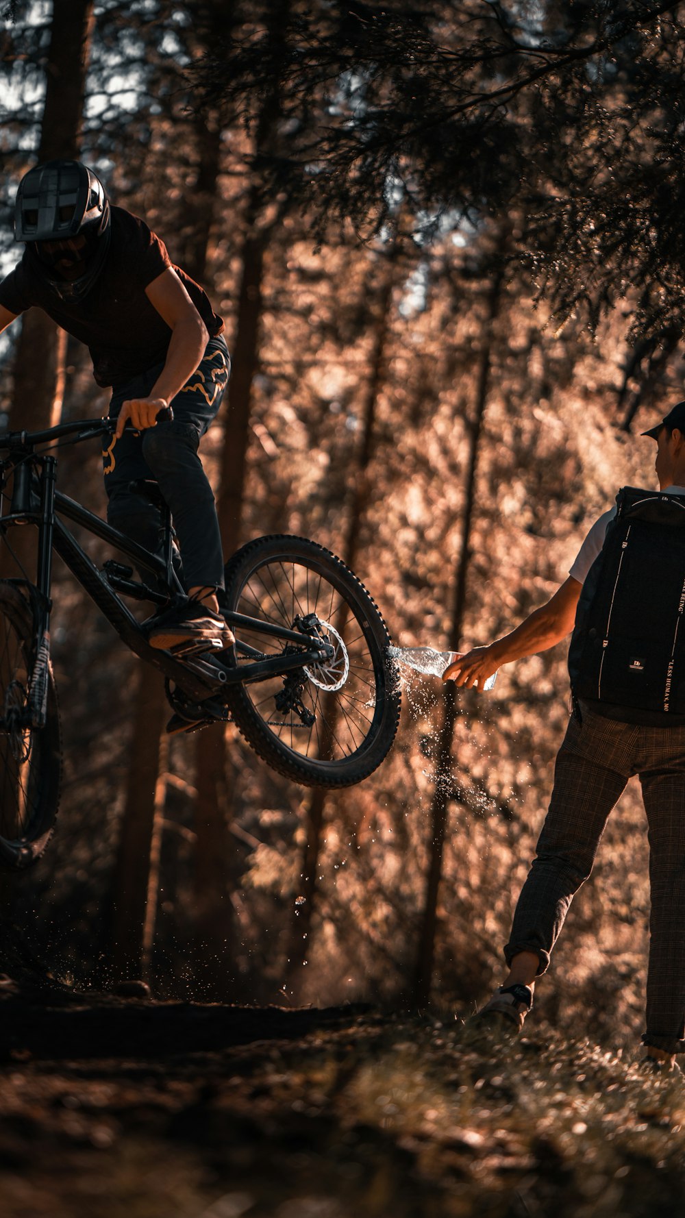 man in black t-shirt and brown pants with black backpack riding on black mountain bike