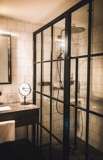 white ceramic sink near black framed glass door