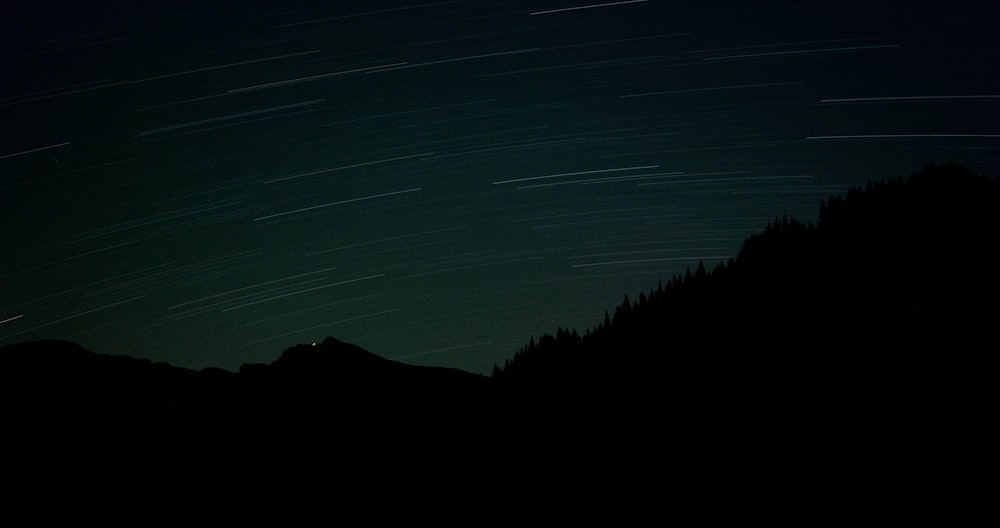 silhouette of mountain under blue sky during night time