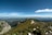 A scenic view of a lush mountain landscape with a winding trail and clear blue skies.