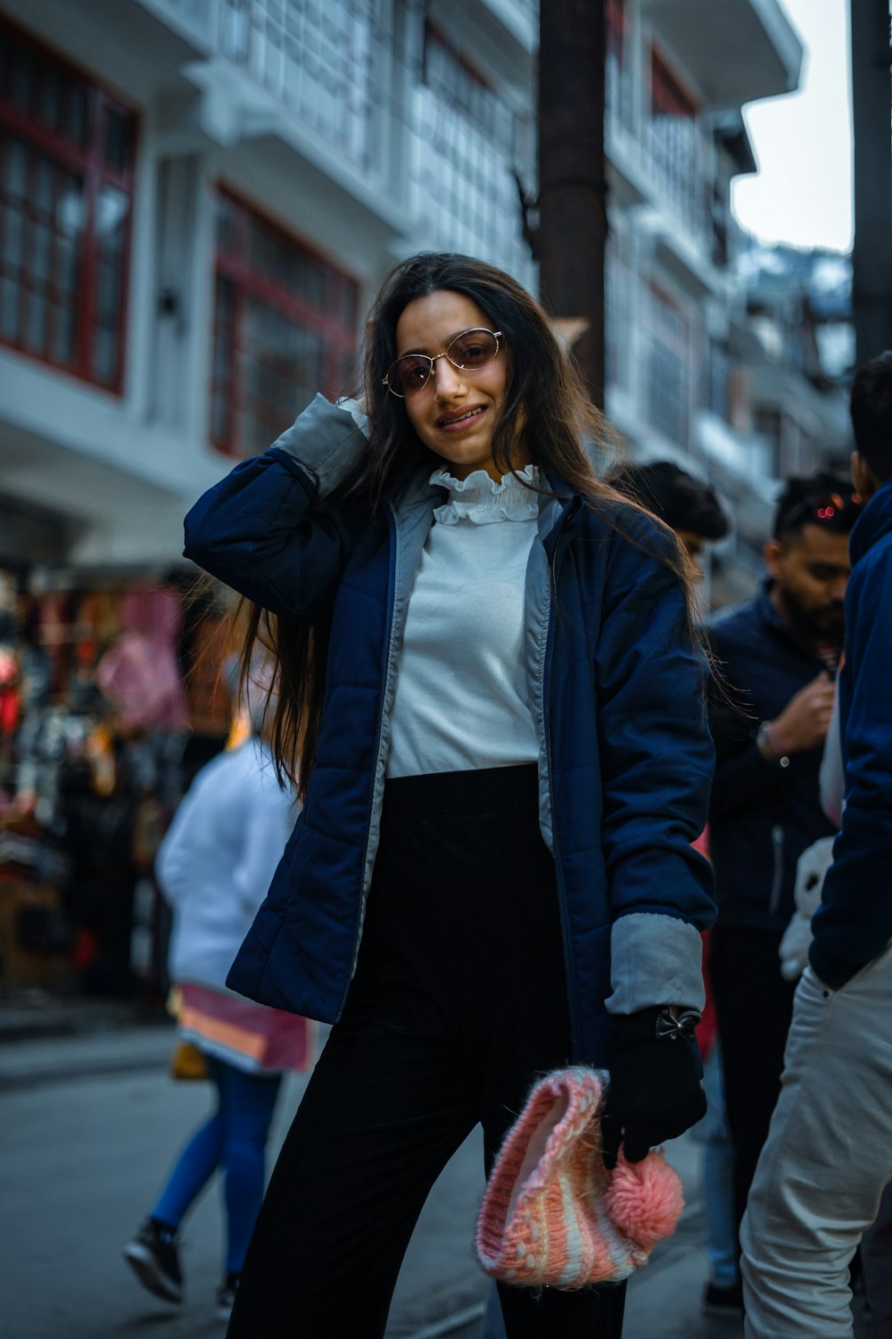 woman in black jacket standing on street during daytime