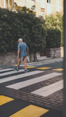 man in blue t-shirt and brown shorts walking on pedestrian lane during daytime
