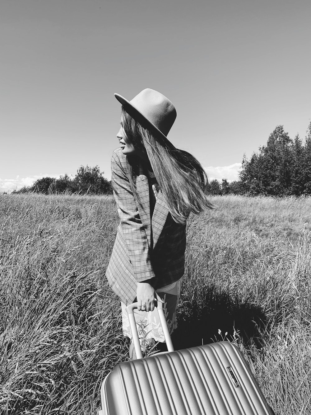 grayscale photo of woman in black long sleeve shirt and black pants standing on grass field