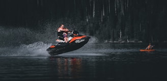 man riding on red and black kayak on river during daytime