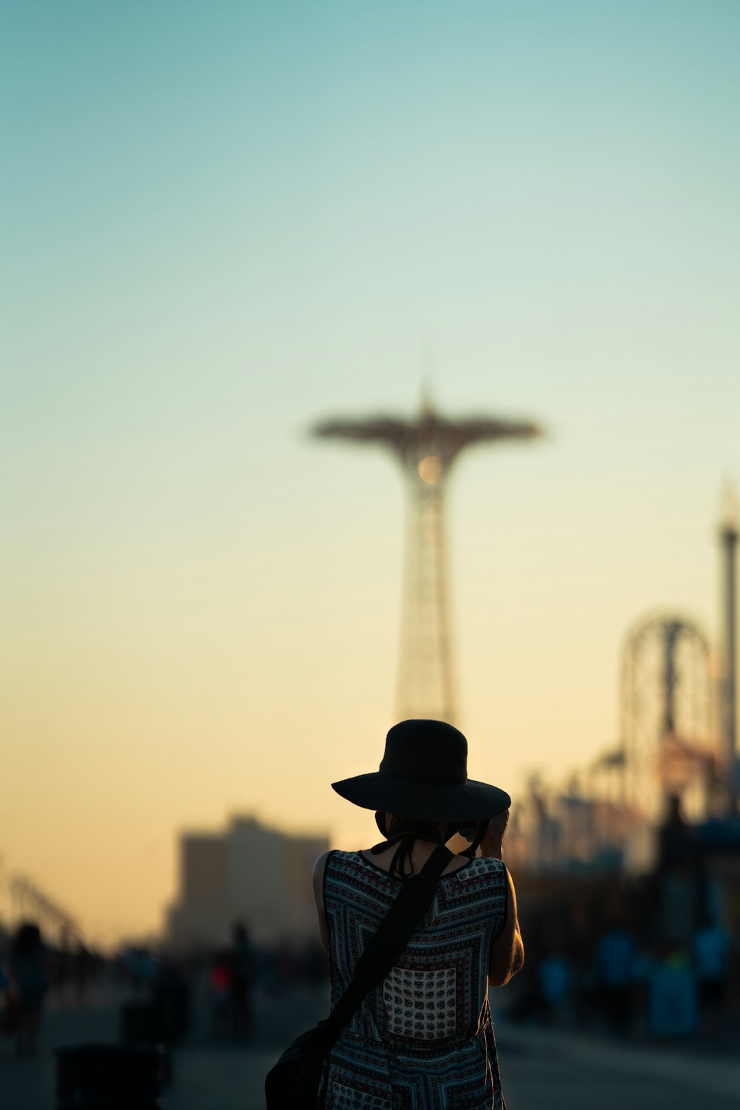 man in blue and white plaid shirt wearing black hat standing near brown tower during daytime