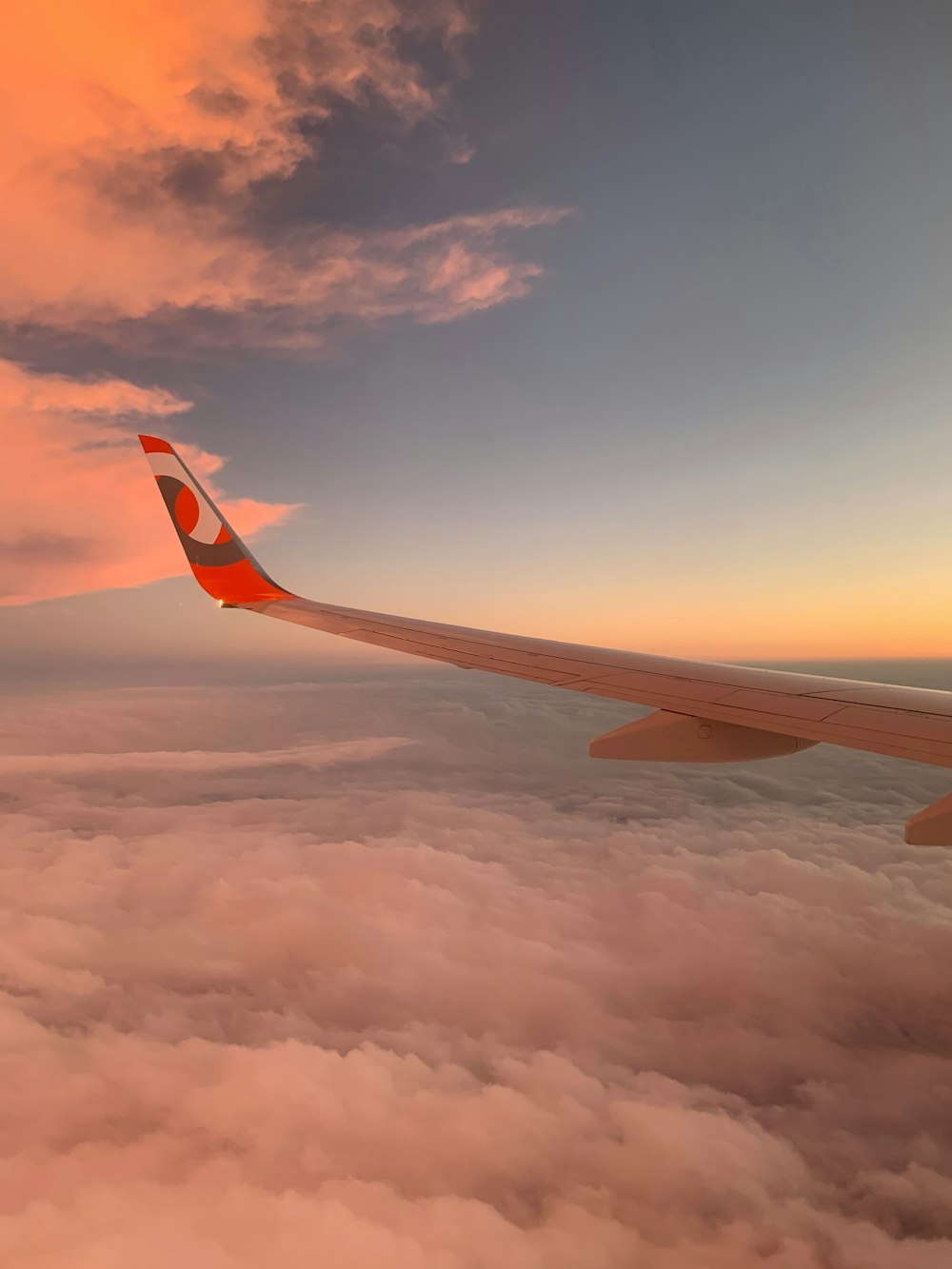 weiß-roter Flugzeugflügel tagsüber unter blauem Himmel