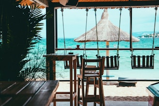 brown wooden beach lounge chair on beach during daytime