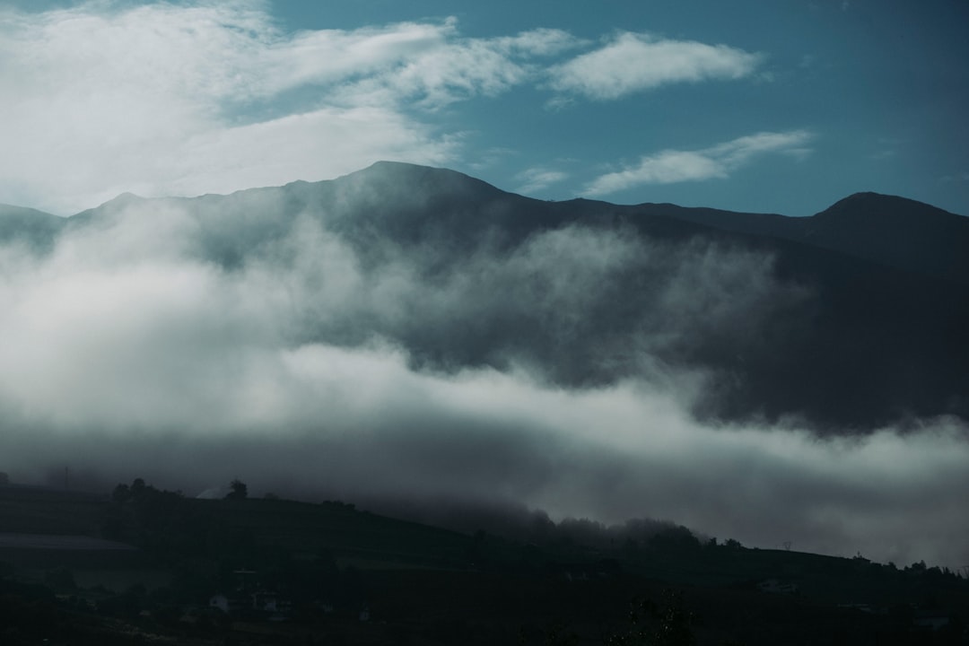 white clouds over mountain during daytime