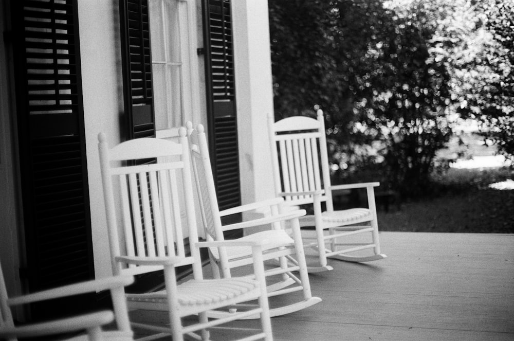 grayscale photo of two rocking chairs