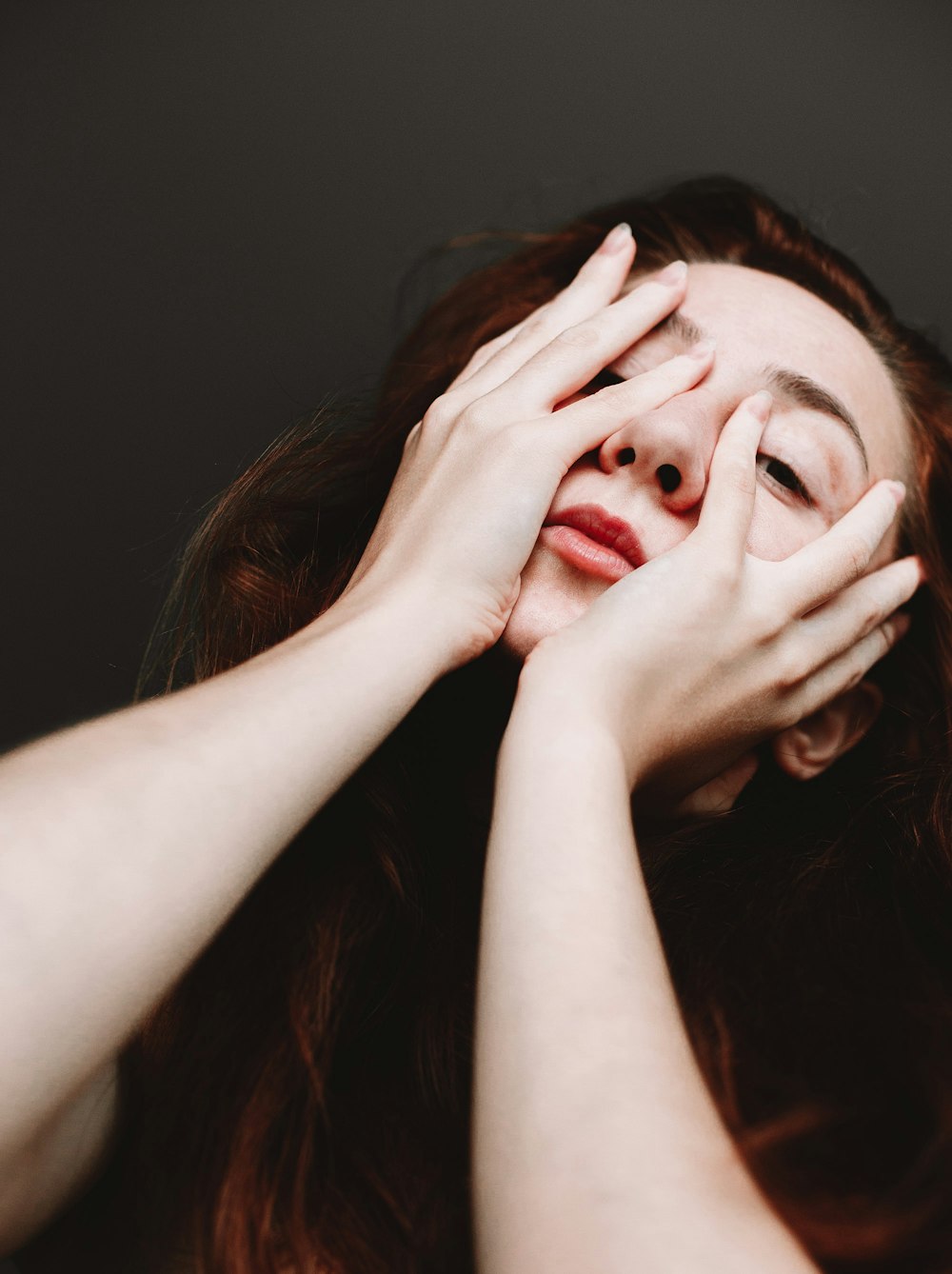 woman covering her face with her hand