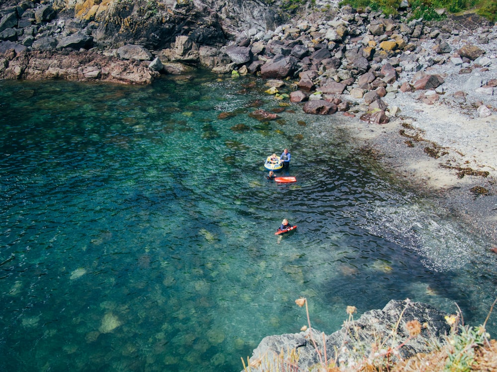 people swimming on blue water during daytime