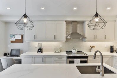 white wooden kitchen cabinet with black pendant lamp