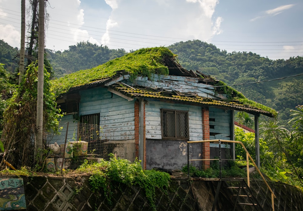 white and brown wooden house near green trees under white clouds during daytime