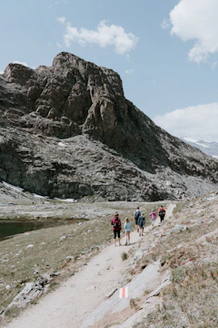 A smiling family hiking together on a scenic mountain trail.