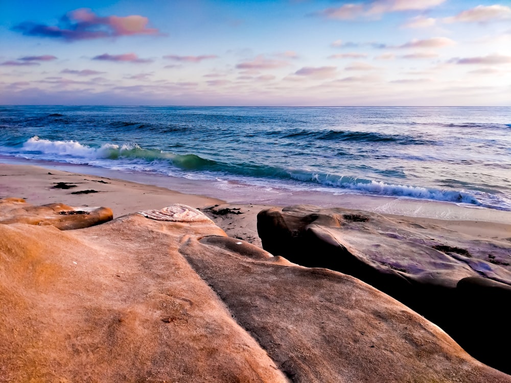 brown rock formation near body of water during daytime