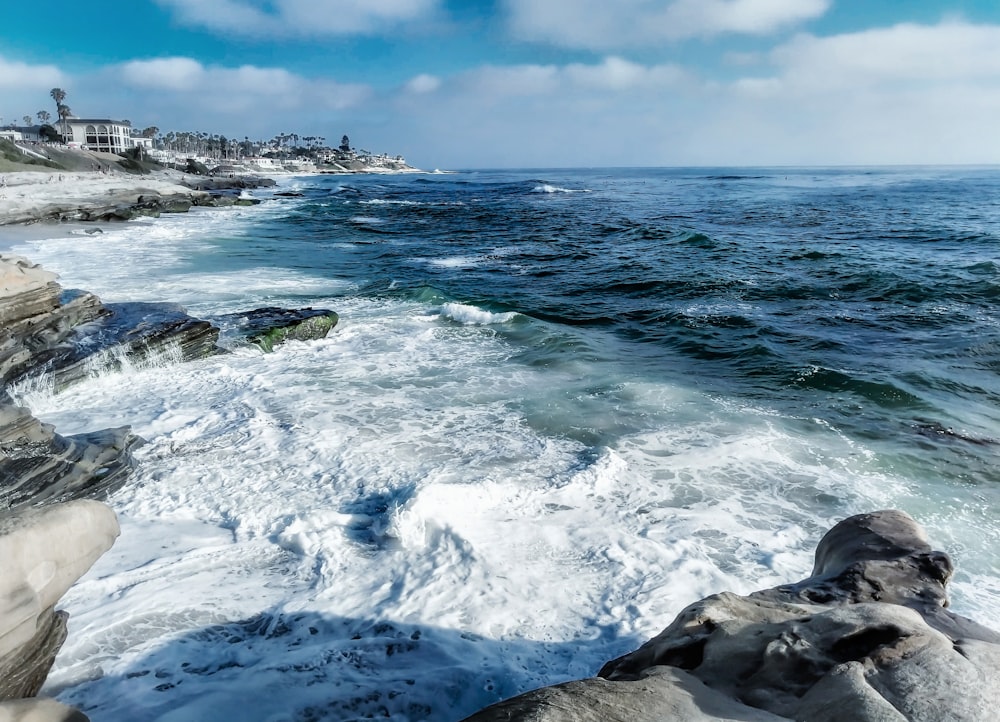 ocean waves crashing on rocky shore during daytime