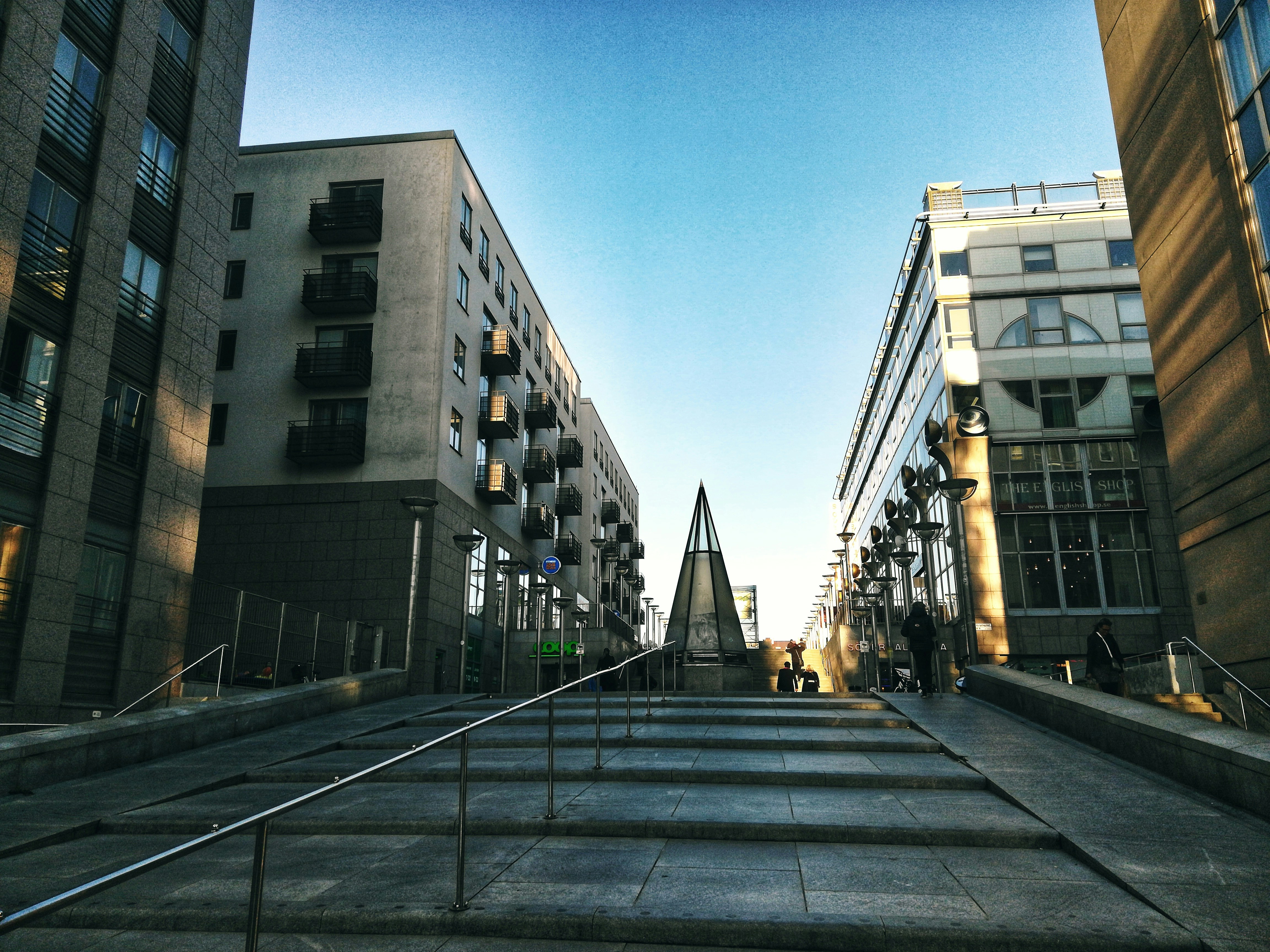 people walking on sidewalk near brown concrete building during daytime, 