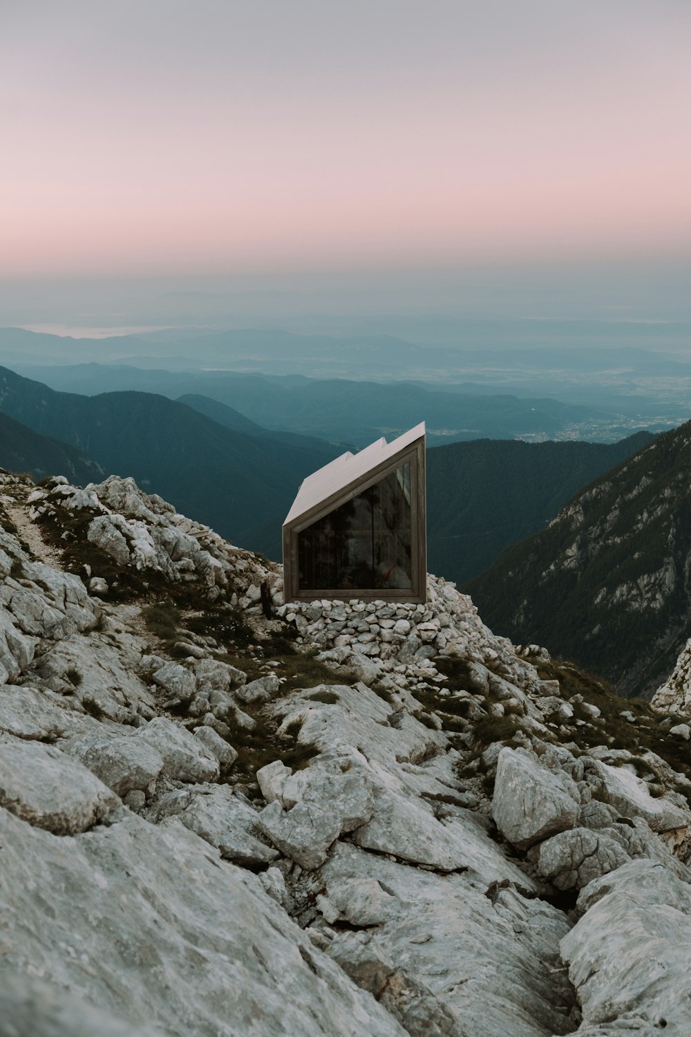 brown wooden house on rocky mountain during daytime