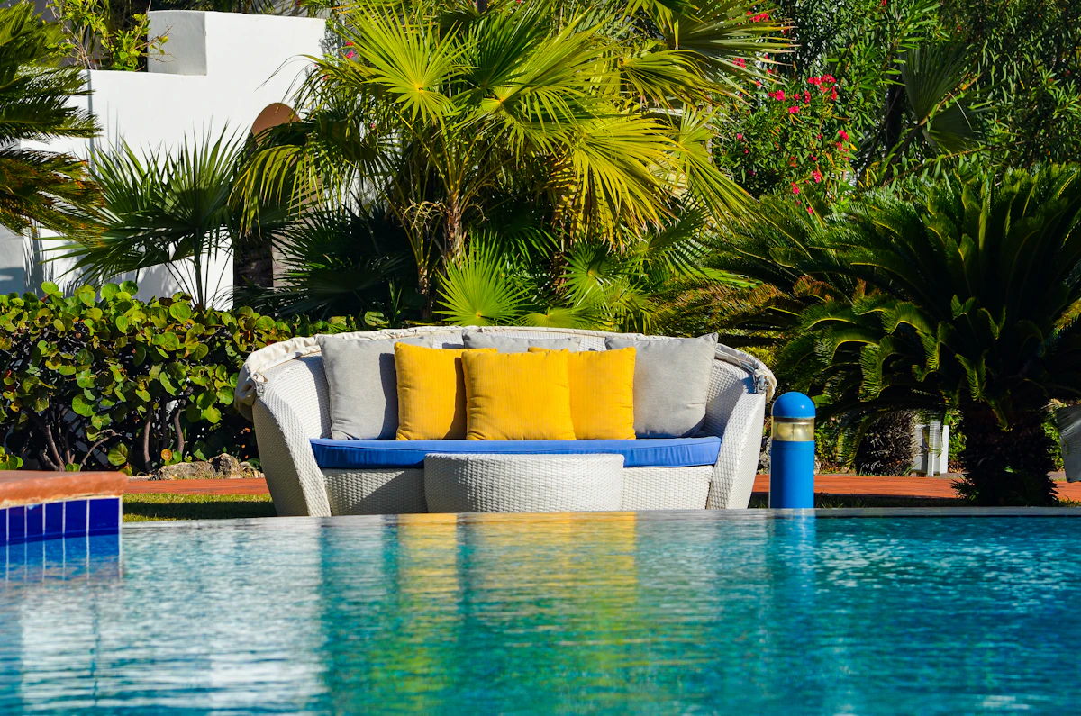 Completed custom residential pool with tropical palm trees and lounge seating in a backyard setting