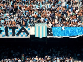 people in a stadium with blue and white curtains
