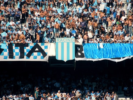people in a stadium with blue and white curtains