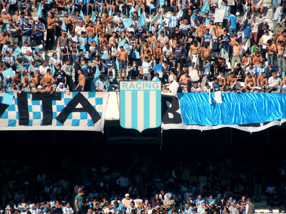 people in a stadium with blue and white curtains
