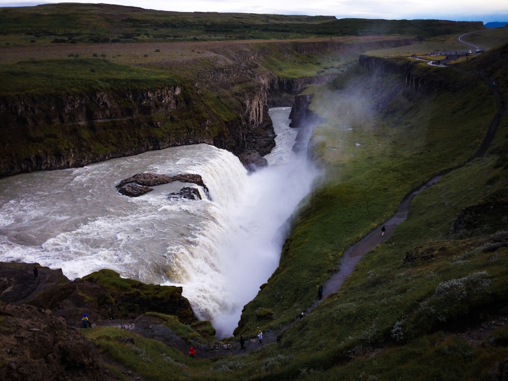 waterfalls on green grass covered hill during daytime