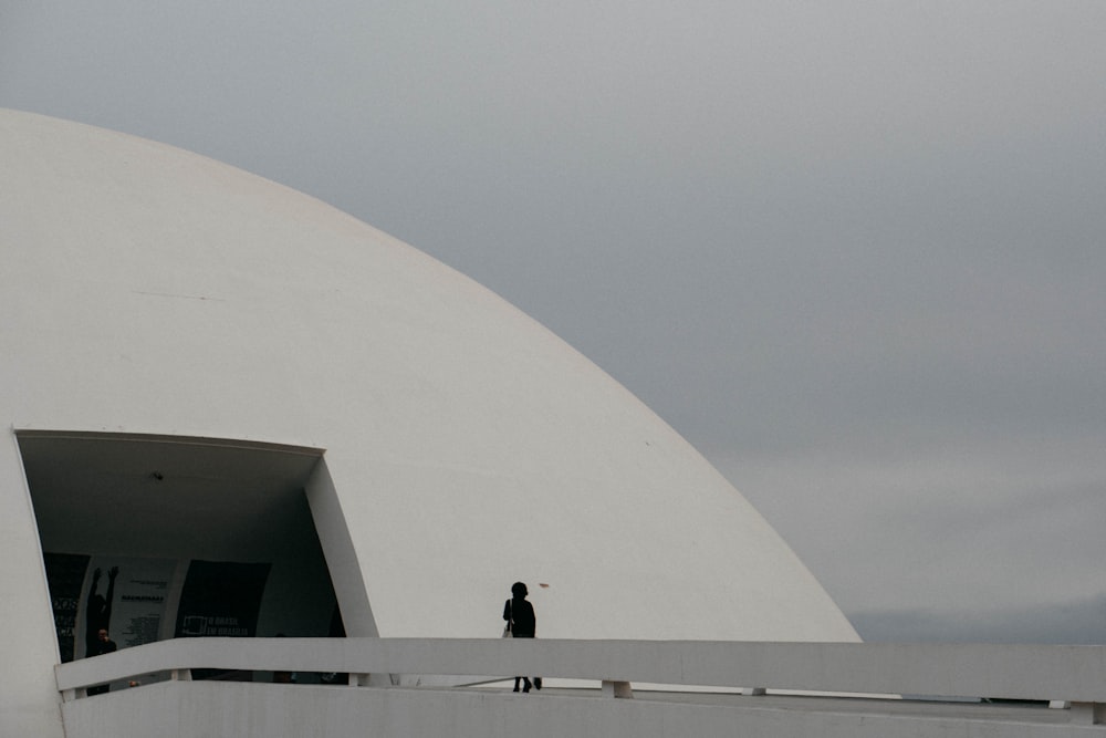 2 person standing on white concrete building during daytime