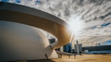people walking on park near white concrete building under gray clouds during daytime