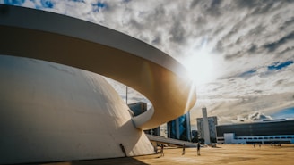 people walking on park near white concrete building under gray clouds during daytime