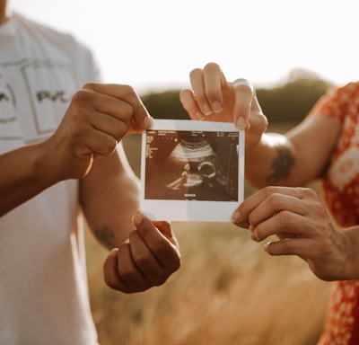 person holding a photo of a man and woman